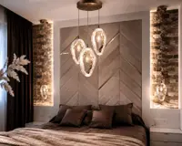 Conjunto de luces colgantes de cristal sobre la cama en un dormitorio con paredes de piedra