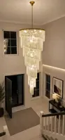 Lámpara de cristal en espiral en un vestíbulo de doble altura con escalera