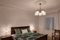 Lámparas de mesa de latón con cúpula de cristal y colgantes de cristal sobre mesillas de noche en un dormitorio